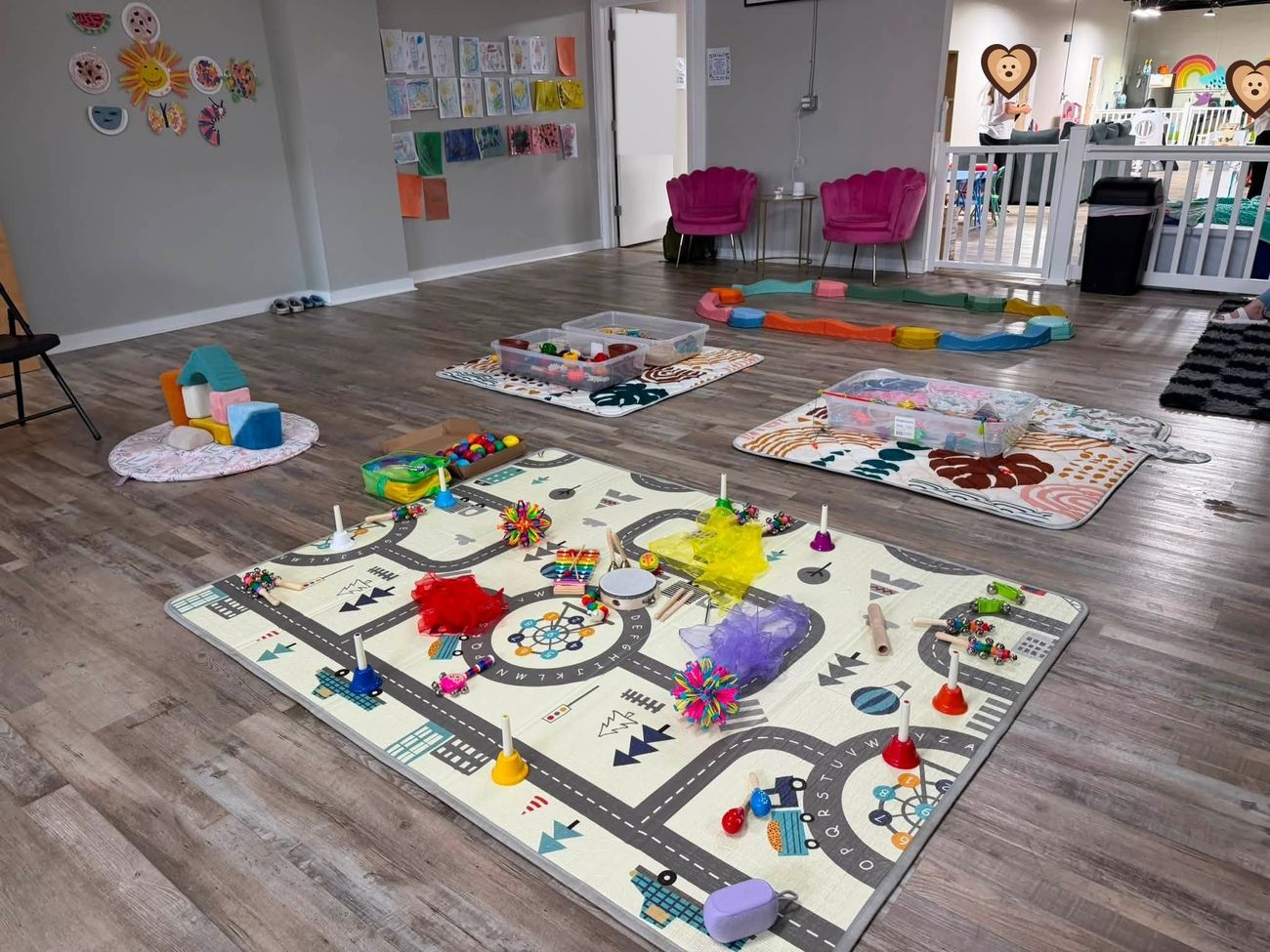 A full Giggles and Growth class setup with sensory bins, instruments and play mats