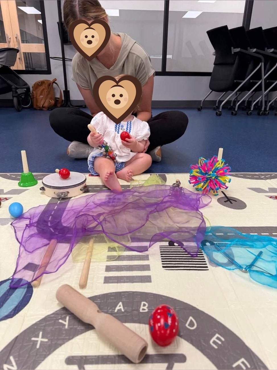 A caregiver and baby playing instruments during music and movement